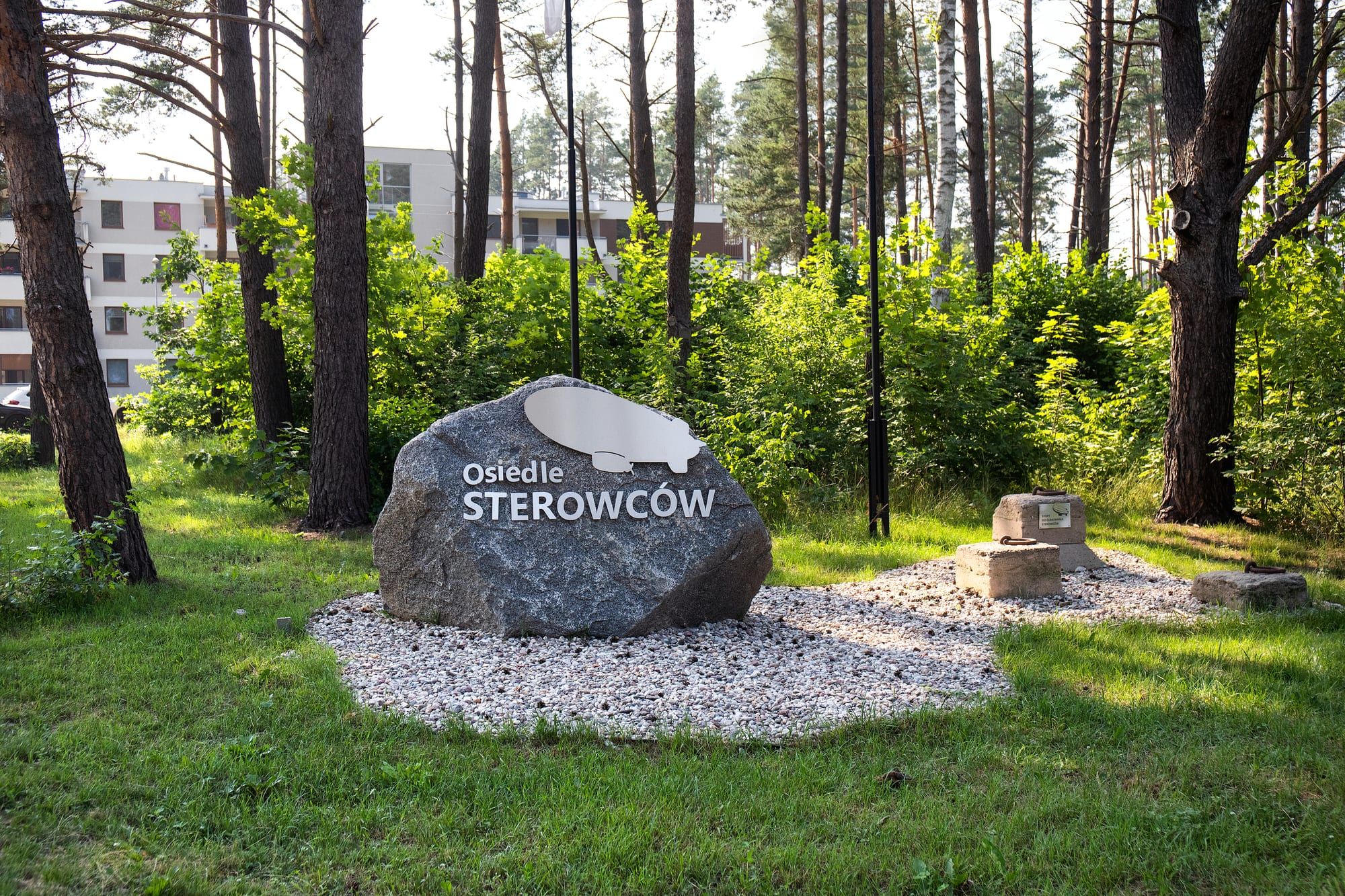 Głaz z napisem Osiedle Sterowców i zachowana betonowa stopa cumownicza dawnej bazy sterowców